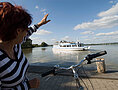 Eine Fahrradfahrerin grüßt die Passagiere der MS Altmühlsee vom Ufer aus