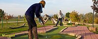 Auf der Minigolfanalge direkt am Seezentrum Schlungenhof am Altmühlsee spielt ein junges Paar gebeistert Minigolf. Die Frau ist gerade dabei den Ball im Loch zu versenken.